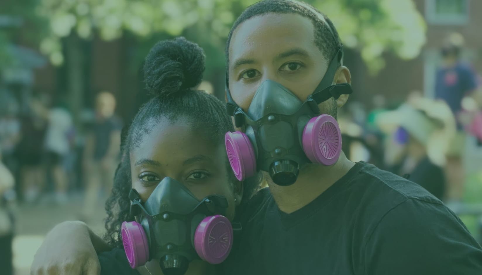 man and woman coworking space members wearing gas masks