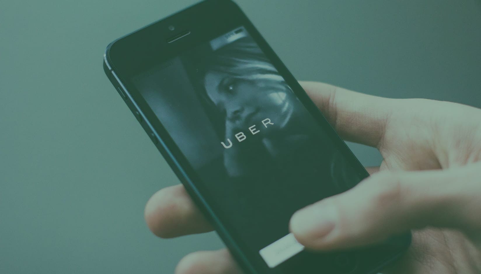 Uber app on the phone as an example of company that started at a coworking space